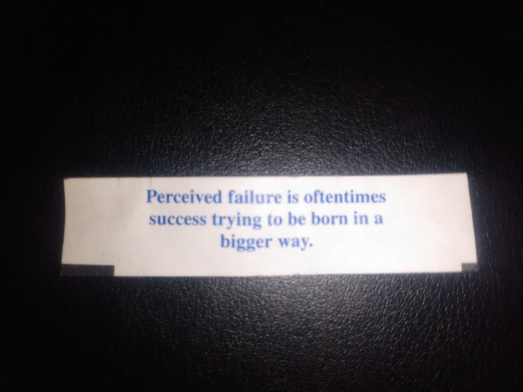 A fortune cookie message that reads: "Perceived failure is oftentimes success trying to be born in a bigger way."