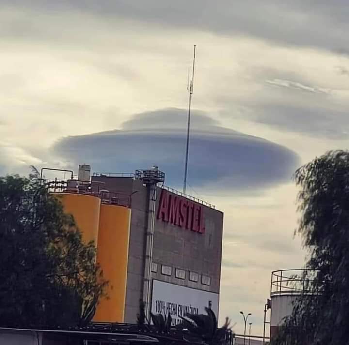 A saucer shaped UFO hiding in the clouds revealed by backlighting. 