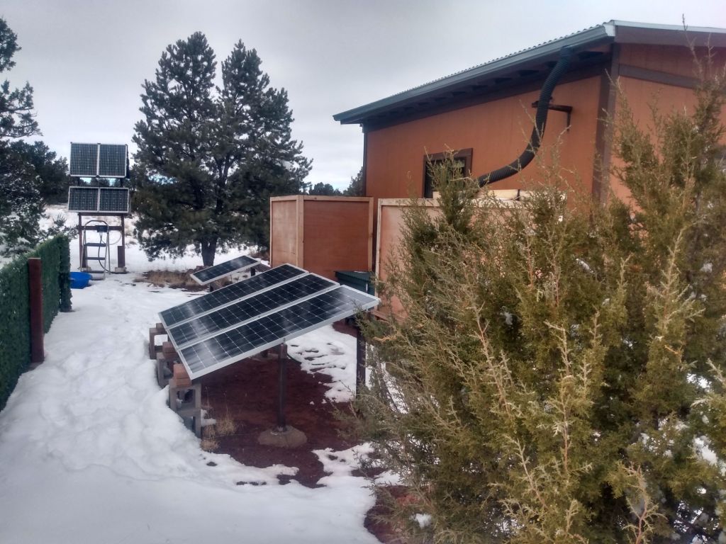 A photograph of a solar array next to a cabin. 